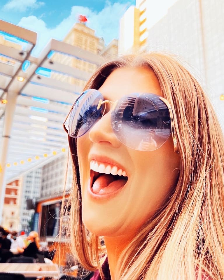 Steavy Carter laughing in retro sunglasses at the AT&T Discovery District — cropped branding moment full of personality.