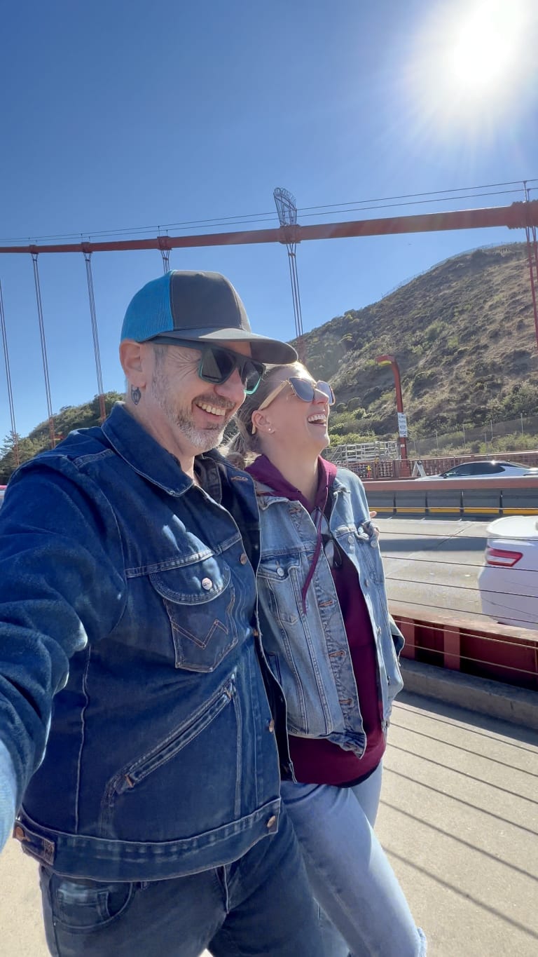 Cool and confident shot of Sean and Steavy Carter wearing sunglasses and jean jackets on the Golden Gate Bridge — dynamic real estate couple.