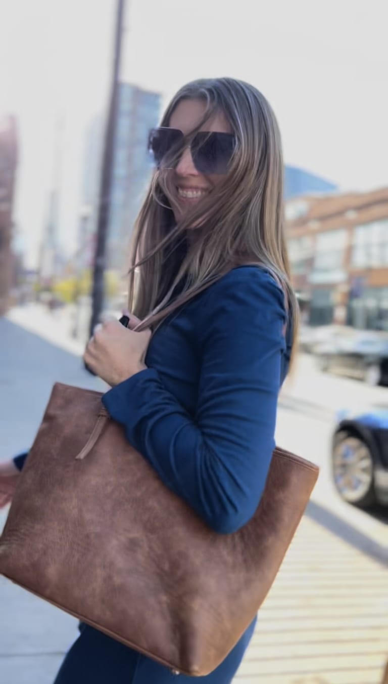 Steavy Carter in a blue dress, smiling while walking — effortless outdoor style and approachable confidence.