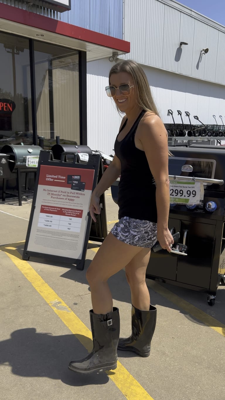 Steavy Carter laughing in mud boots outside Tractor Supply — down-to-earth, country charm brand moment.