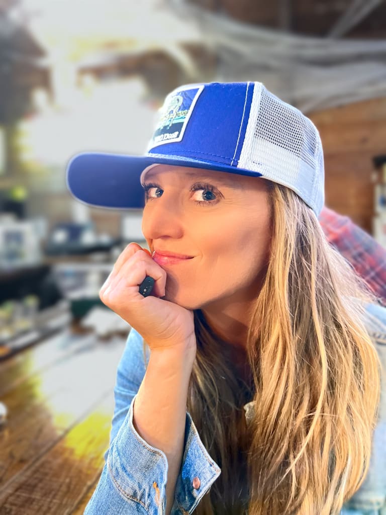 Steavy Carter giving a sultry glance while wearing a blue hat — confident and stylish brand photo.