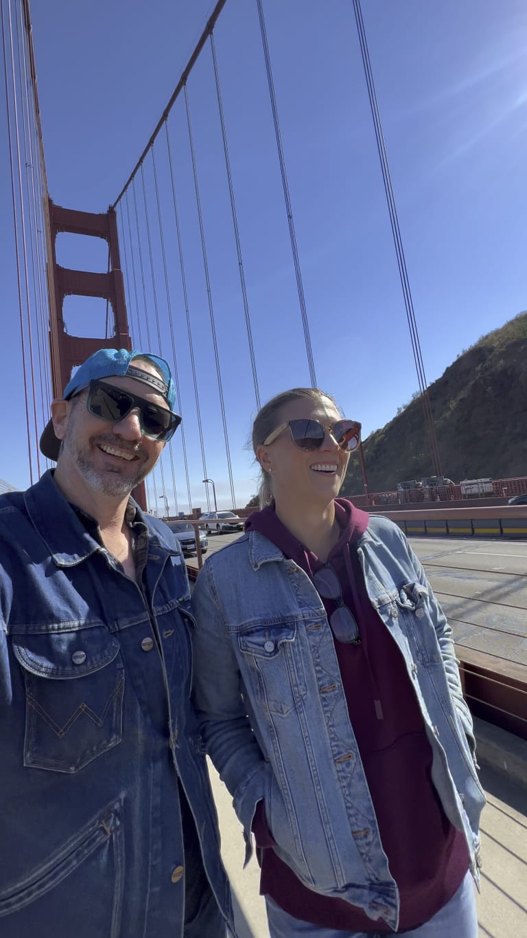 Sean and Steavy Carter walking side by side in denim jackets on the Golden Gate Bridge — united and stylish real estate duo.