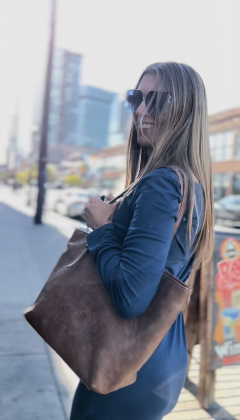 Steavy Carter laughing brightly in a blue dress with her hair flowing — light and welcoming brand moment.