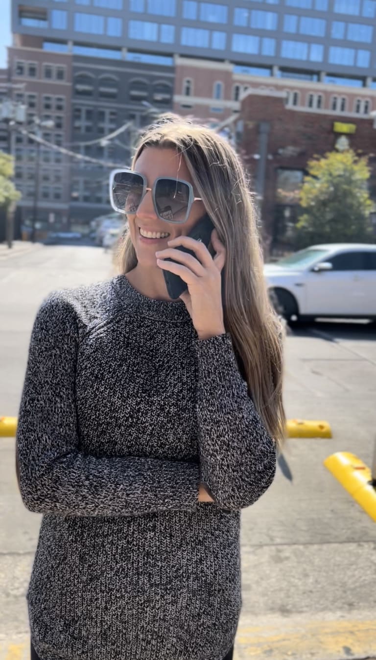 Close-up of Steavy Carter on the phone in a gray sweater — personable, modern, and real estate ready.