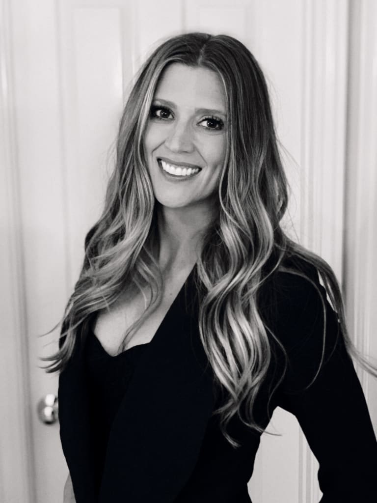 Steavy Carter in a black dress with cascading long hair, captured in black and white — graceful and classic brand image.