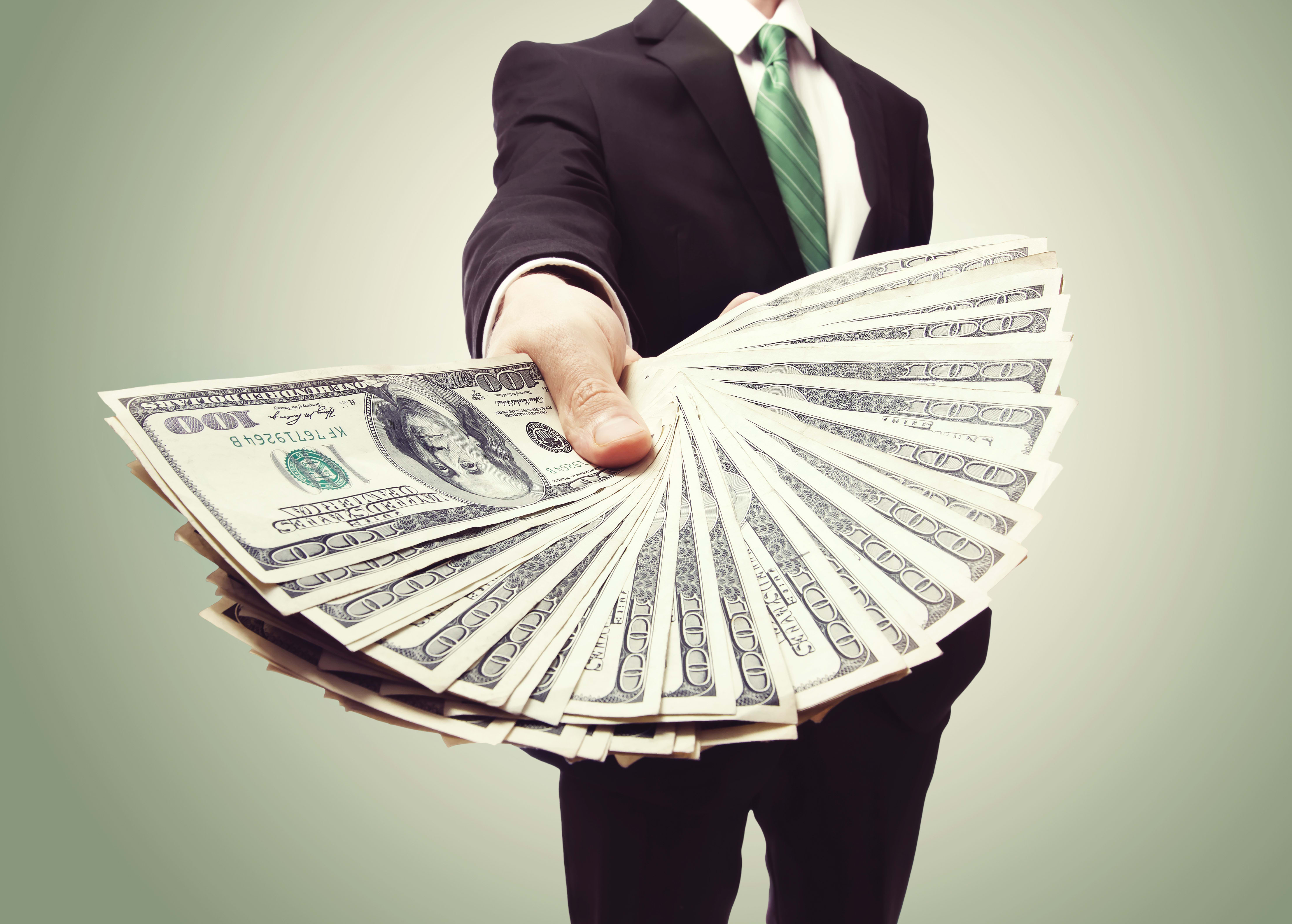 Foreign Nationals - Commonly Required Documents For Second Home and Luxury Purchases inception-app-prod/ZTBmODhmM2QtOTIwNy00NzcwLWFmYzMtNjM2ZjA0MmMzYjg1/content/2017/03/Business Man Displaying a Spread of Cash over a green vintage background - shutterstock_146762978.jpg