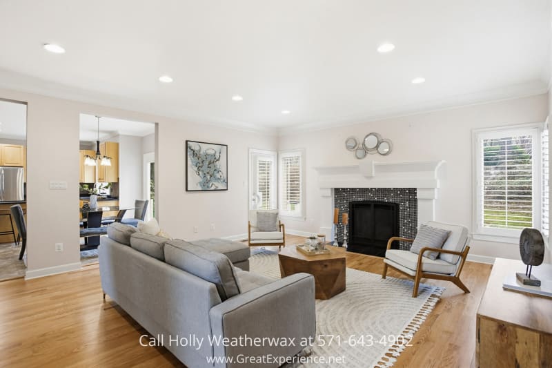 11316 Bright Pond Lane 26 Bright family room at 11316 Bright Pond Lane, Reston, VA, featuring hardwood floors, fireplace, and open flow to dining and kitchen areas.