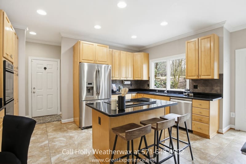 11316 Bright Pond Lane 25 Spacious kitchen at 11316 Bright Pond Lane, Reston, VA featuring a center island with seating, stainless steel appliances, ample cabinetry, and bright windows overlooking the yard.